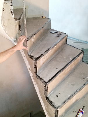 Photo de présentation des profils d'angles installés sur les marches d'un escalier avant le béton ciré