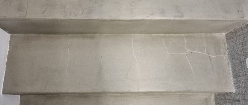 marche d'un escalier en béton ciré fissurée