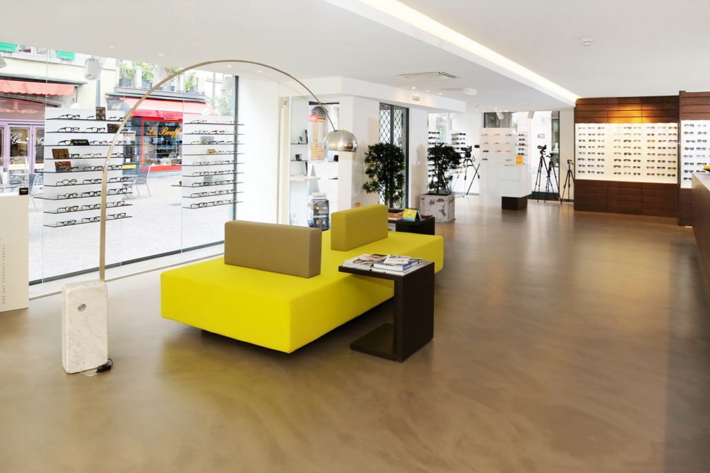 Zone d'attente rénovée en béton ciré dans un centre optique