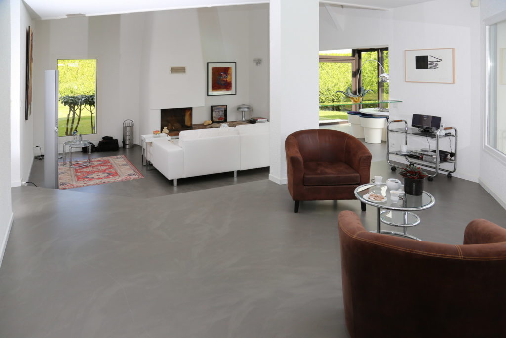 Zone salon avec un sol en béton ciré